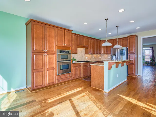 a kitchen with stainless steel appliances granite countertop a refrigerator and a stove top oven