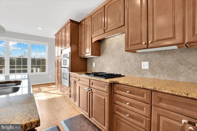 a kitchen with granite countertop wooden cabinets and white appliances