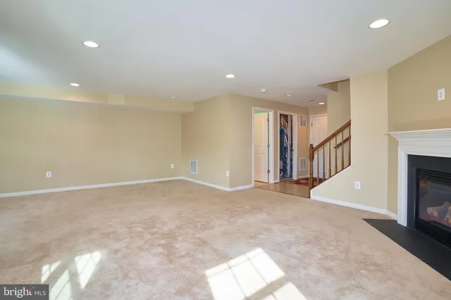 a view of an empty room with fireplace and a window