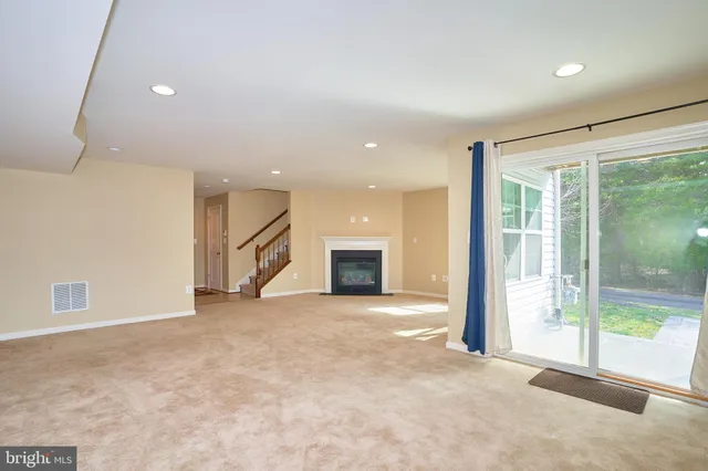 a view of an empty room with a fireplace and a window