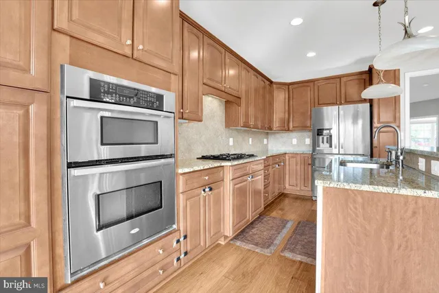 a kitchen with stainless steel appliances granite countertop a stove a sink and a microwave