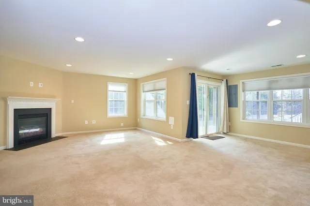 a view of an empty room with a fireplace and a large window