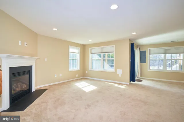 a view of an empty room with a fireplace and a window