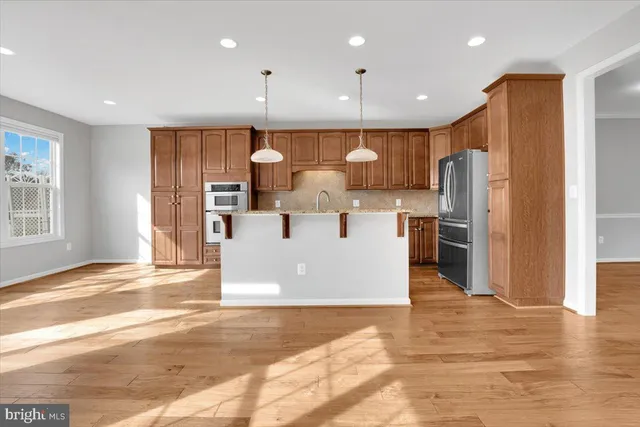 a view of kitchen with stainless steel appliances refrigerator oven and cabinets