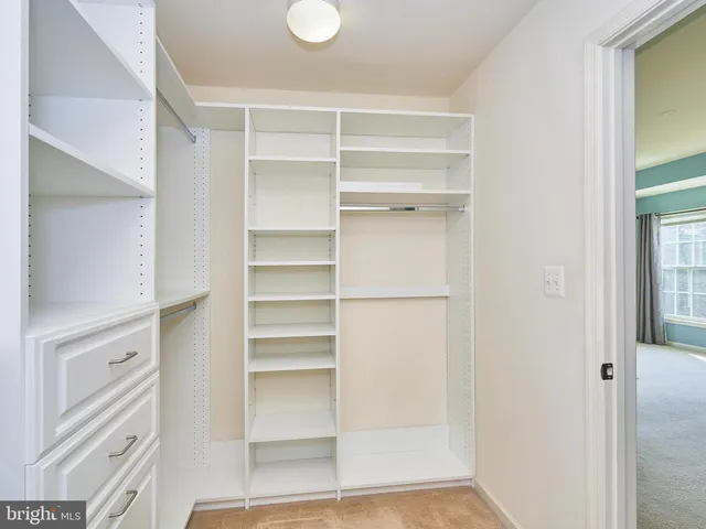 a view of walk in closet with empty racks
