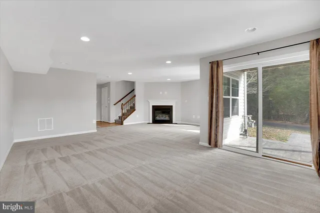 a view of a livingroom with wooden floor and a fireplace