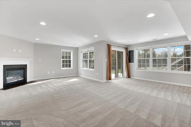 a view of an empty room with a window and fireplace