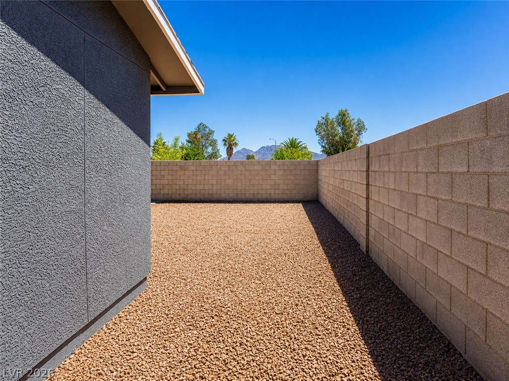 2870 South Sandhill Road Las Vegas, NV 89121 - Photo 23 of 64 Secure yard featuring robust block fencing and low-maintenance gravel landscaping.