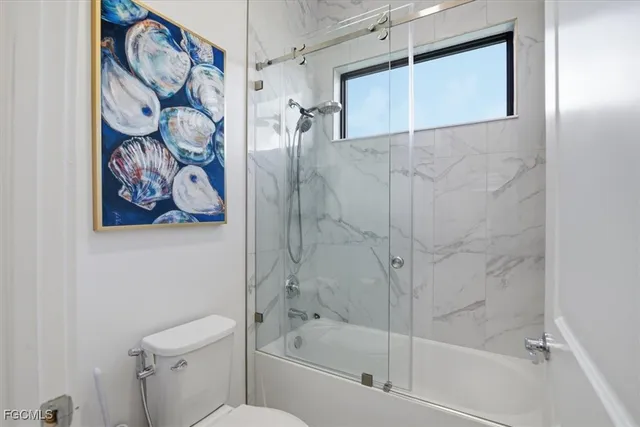 a bedroom with a bed a couch and a flat screen tv