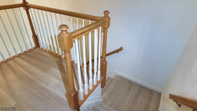 a view of staircase with railing and white walls