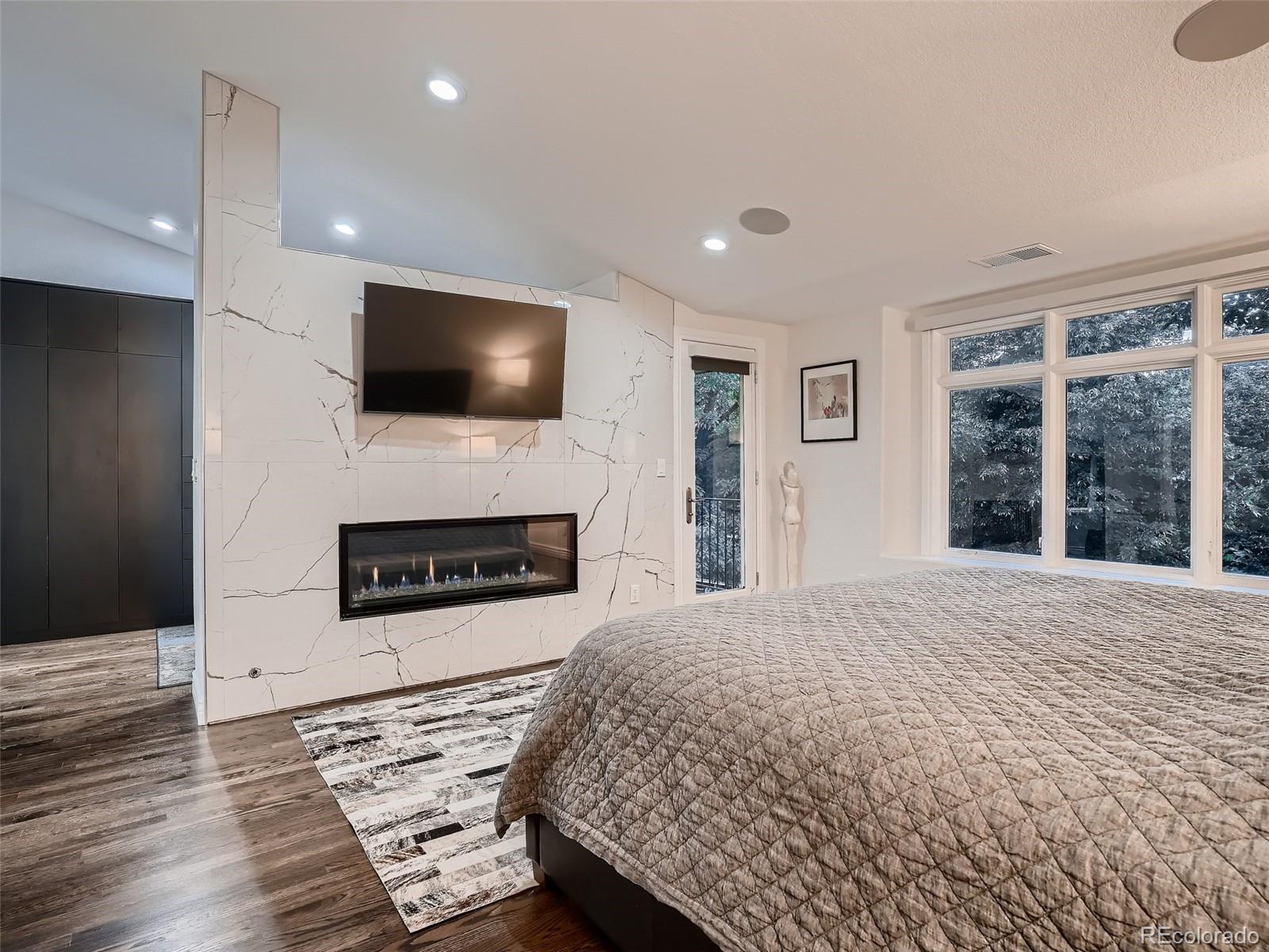 338 St Paul Street Denver, CO 80206 - Photo 23 of 40 a spacious bedroom with a bed and a flat screen tv
