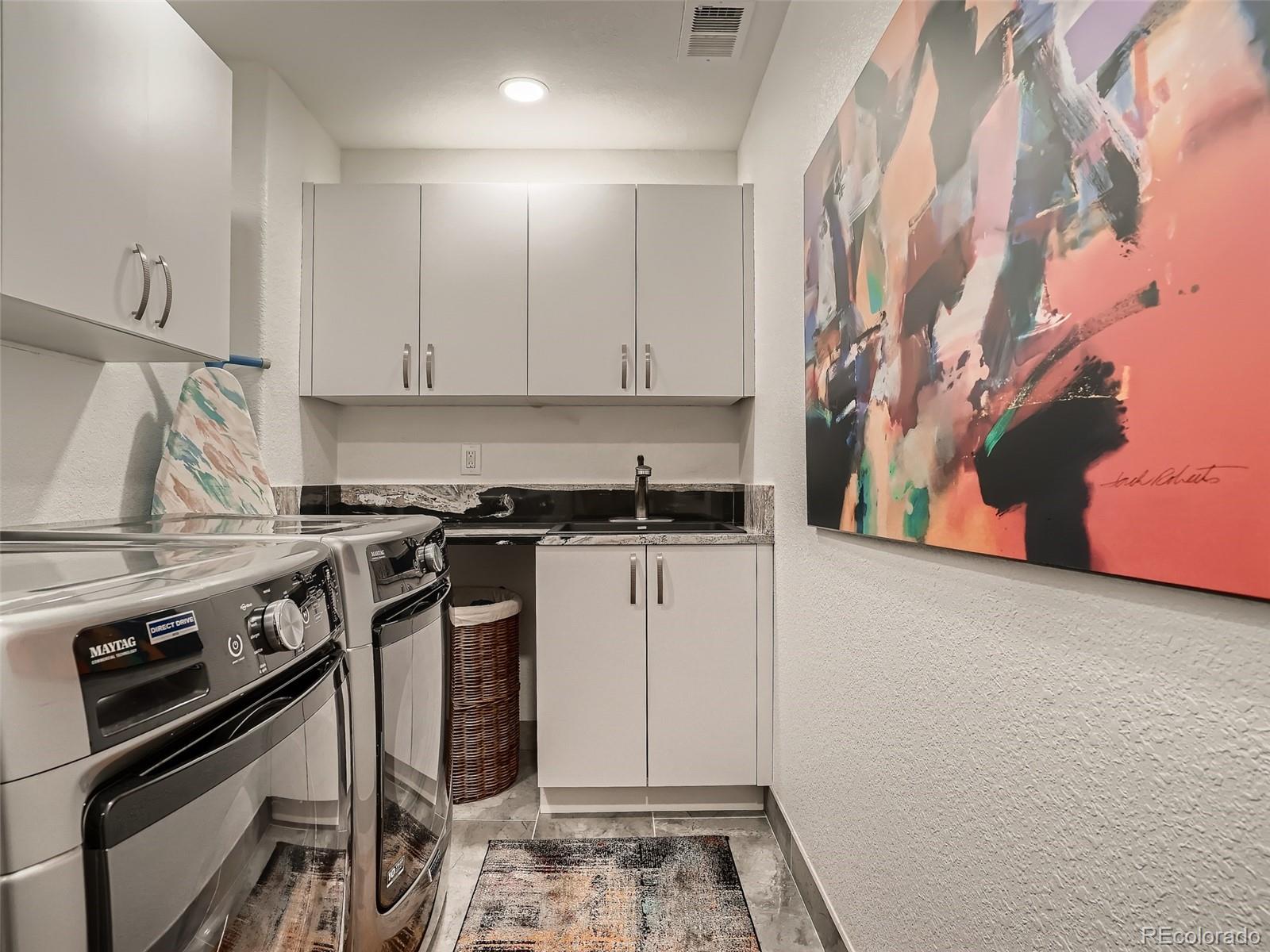 338 St Paul Street Denver, CO 80206 - Photo 32 of 40 a kitchen with a stove and a white cabinet
