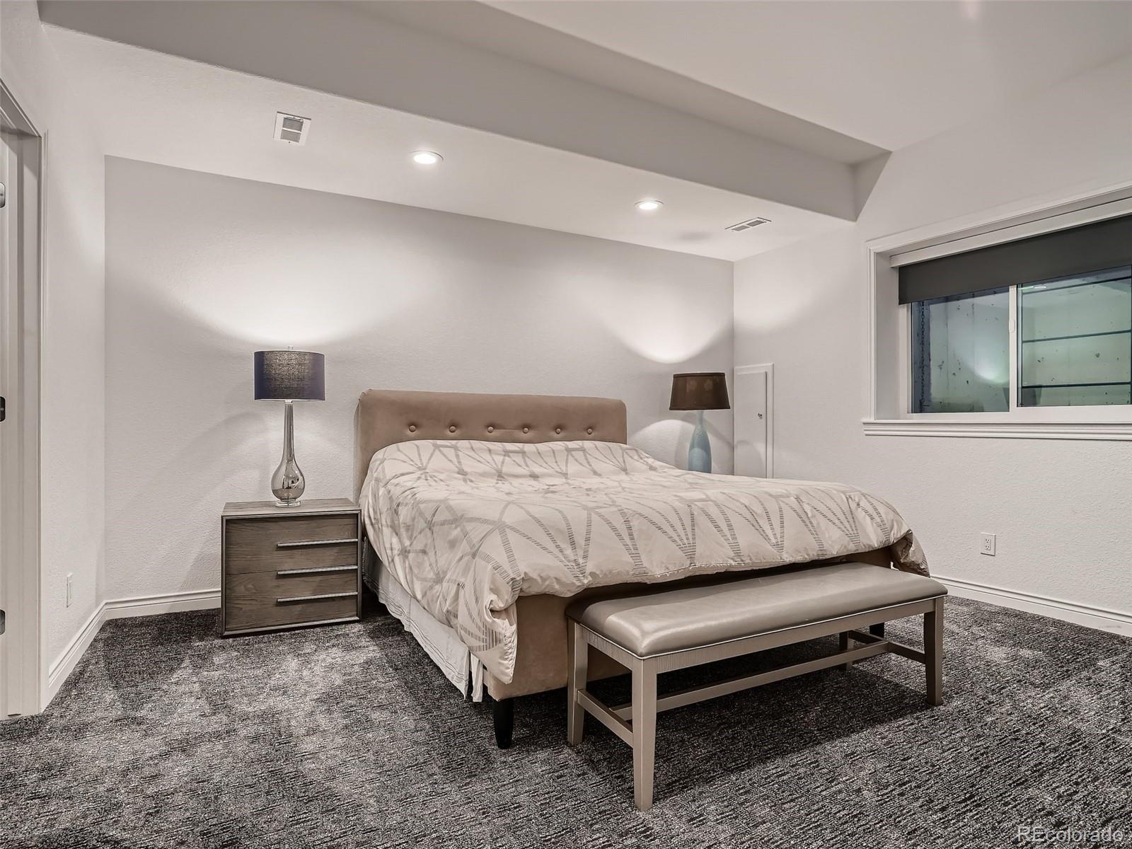 338 St Paul Street Denver, CO 80206 - Photo 37 of 40 a bedroom with a bed and a night stand