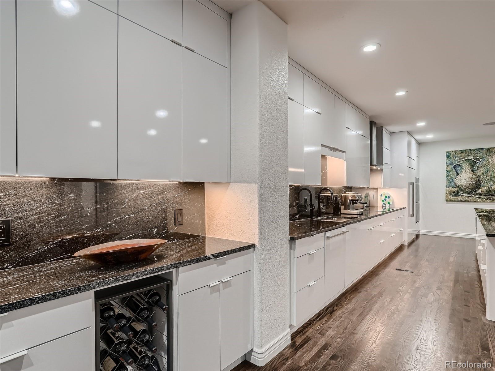 338 St Paul Street Denver, CO 80206 - Photo 10 of 40 a large kitchen with stainless steel appliances granite countertop a sink and cabinets