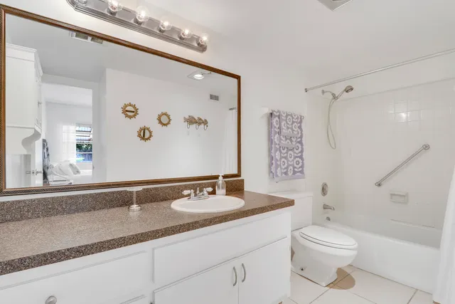a bathroom with a granite countertop sink toilet a large mirror a shower and vanity