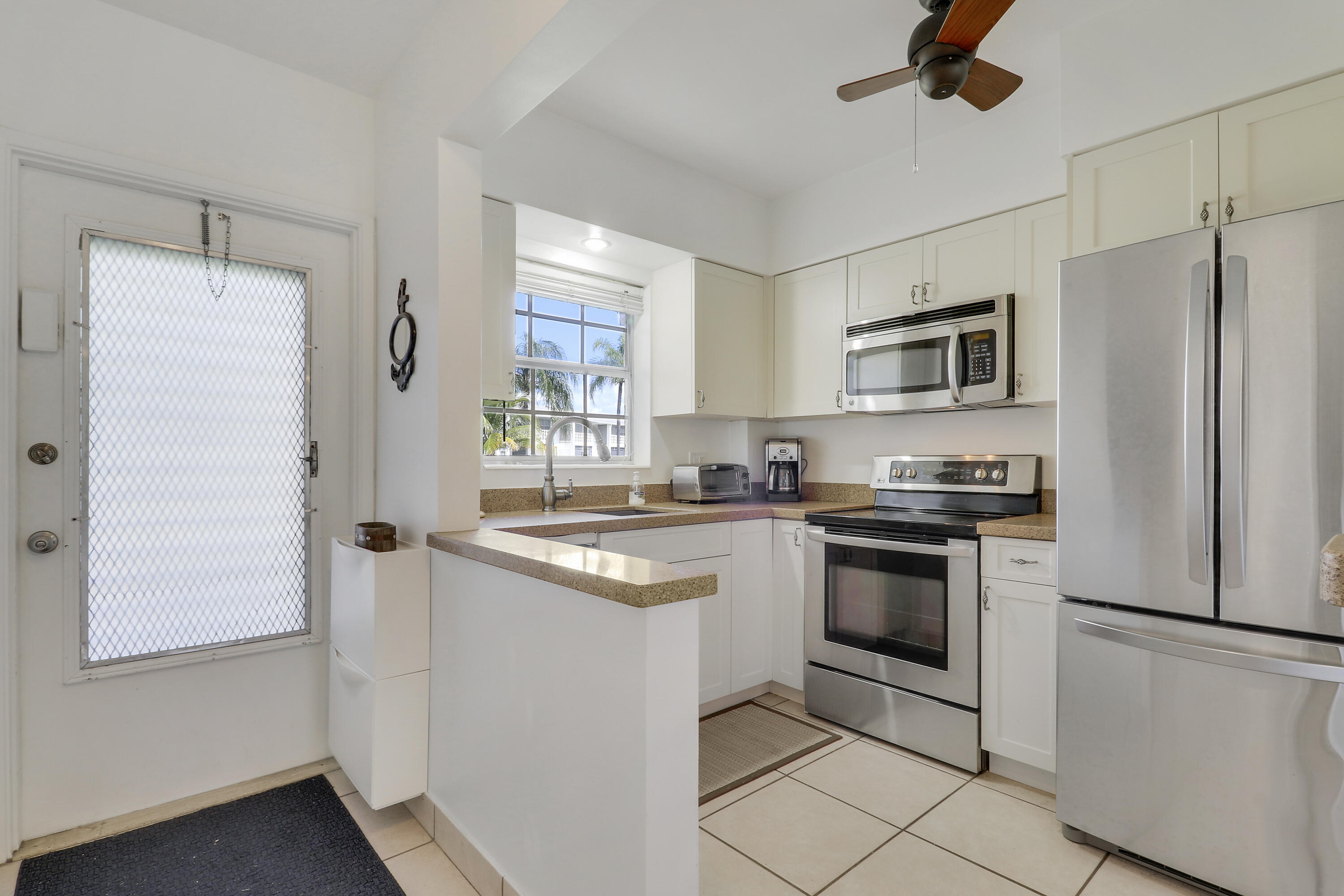 298 Southeast 6th Avenue, Unit 6 Pompano Beach, FL 33060 - Photo 15 of 36 a kitchen with stainless steel appliances granite countertop a refrigerator a stove a sink and a microwave