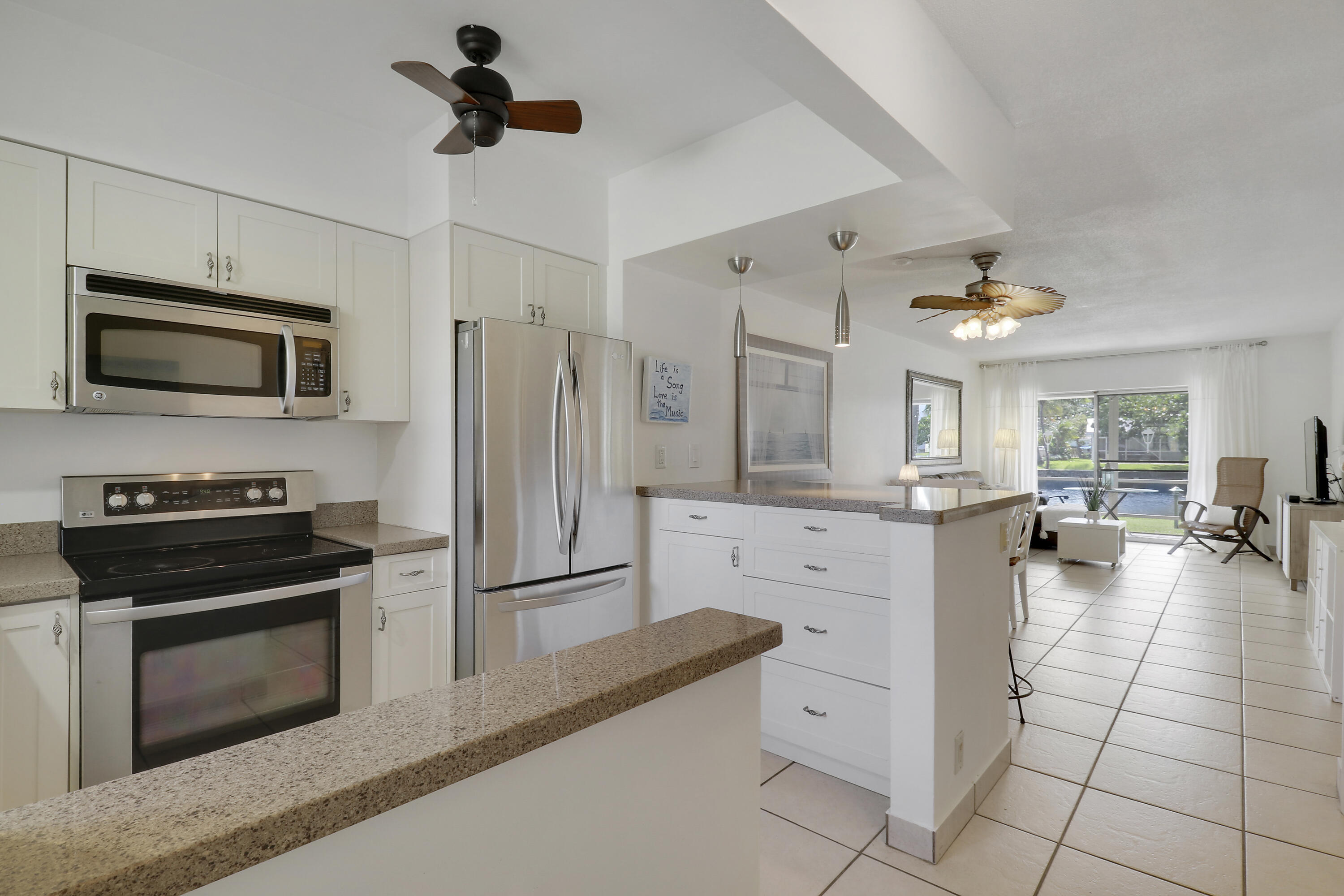 298 Southeast 6th Avenue, Unit 6 Pompano Beach, FL 33060 - Photo 17 of 36 a kitchen with white cabinets and stainless steel appliances