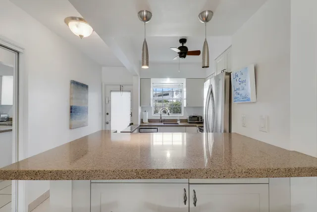 a view of a kitchen with a sink granite counter top space and living room