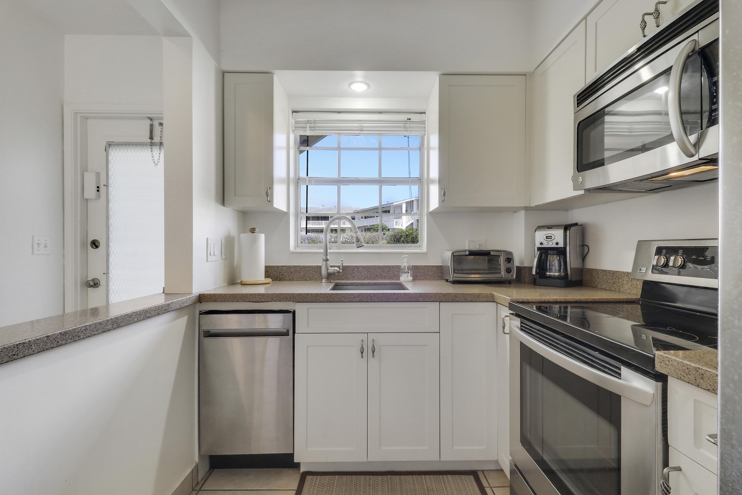 298 Southeast 6th Avenue, Unit 6 Pompano Beach, FL 33060 - Photo 19 of 36 a kitchen with cabinets appliances a sink and a window