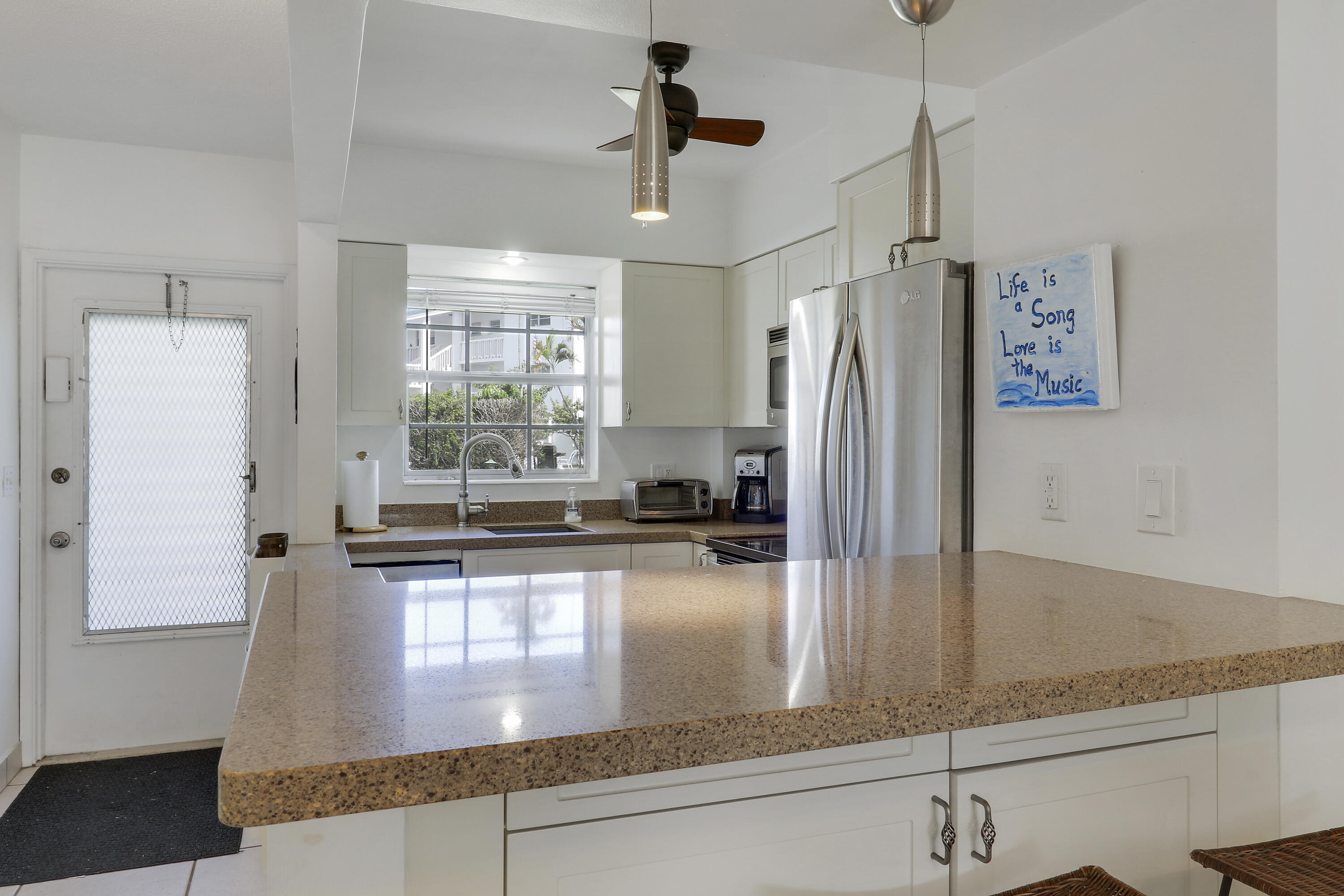 298 Southeast 6th Avenue, Unit 6 Pompano Beach, FL 33060 - Photo 21 of 36 a kitchen with stainless steel appliances granite countertop a refrigerator a stove and white cabinets with wooden floor