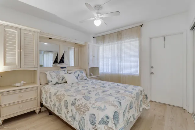a bedroom with a large bed and a chandelier fan