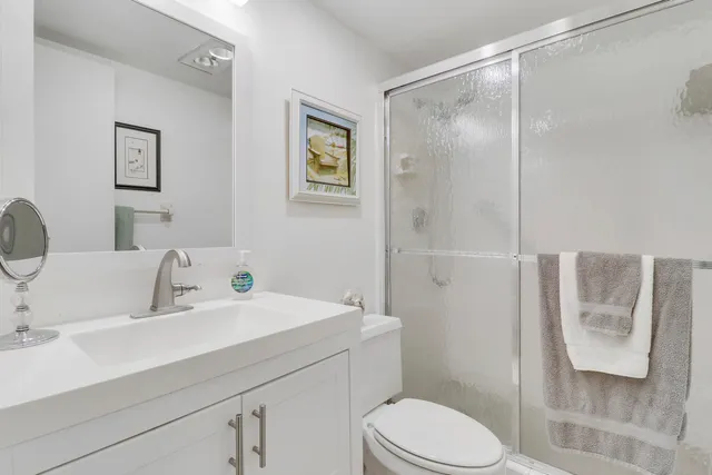 a bathroom with a sink mirror vanity and toilet