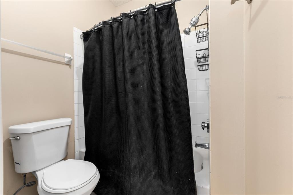 10000 Southwest 52nd Avenue, Unit 35 Gainesville, FL 32608 - Photo 18 of 36 a white toilet sitting next to a shower curtain