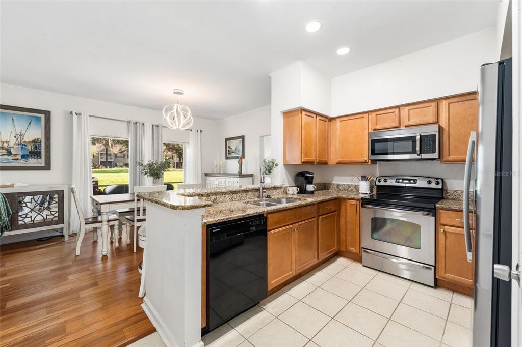 10000 Southwest 52nd Avenue, Unit 35 Gainesville, FL 32608 - Photo 10 of 36 a kitchen with granite countertop a stove top oven and sink