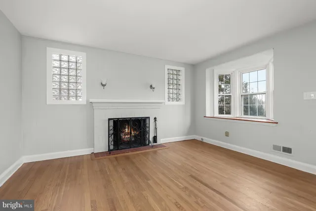 an empty room with windows and a fireplace