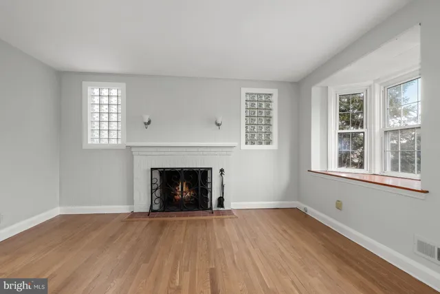 an empty room with windows and a fireplace