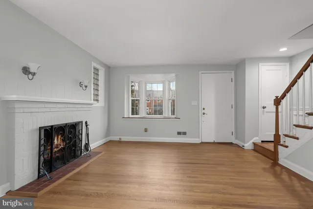 a view of empty room with wooden floor and fireplace