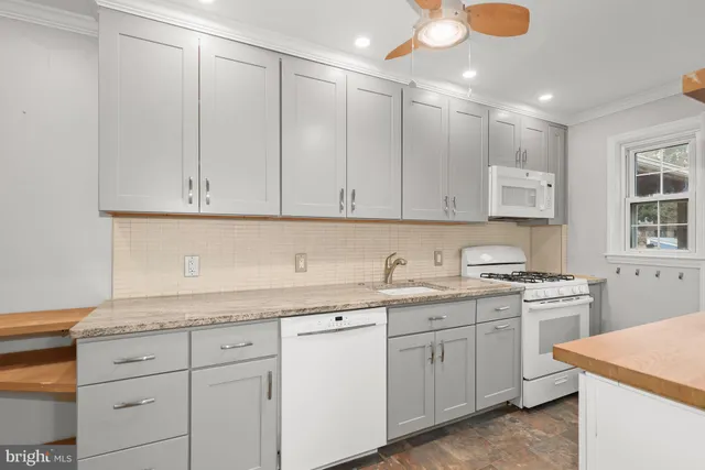 a kitchen with white cabinets and white appliances