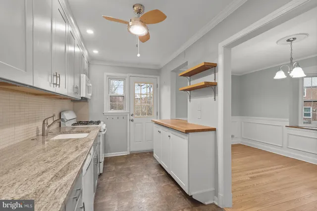 a kitchen that has a lot of cabinets in it and wooden floors