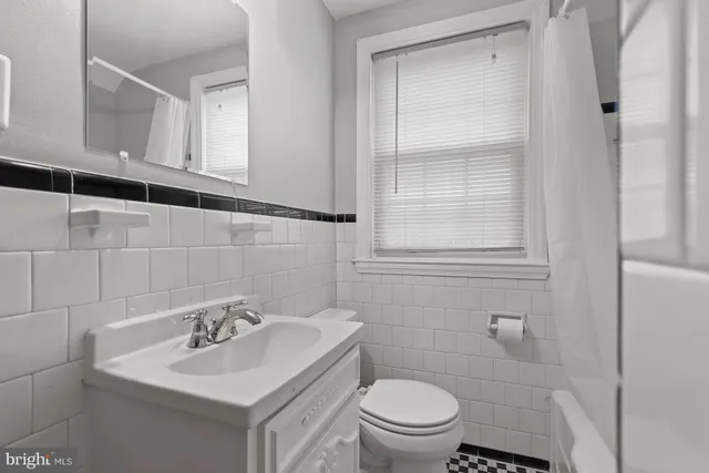 a bathroom with a toilet sink vanity and mirror