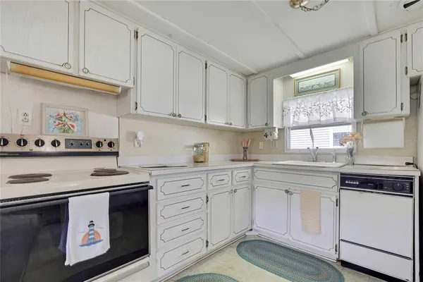 a kitchen with granite countertop white cabinets and white appliances