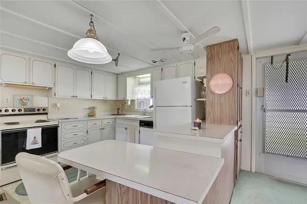 a kitchen with cabinets appliances and a chandelier