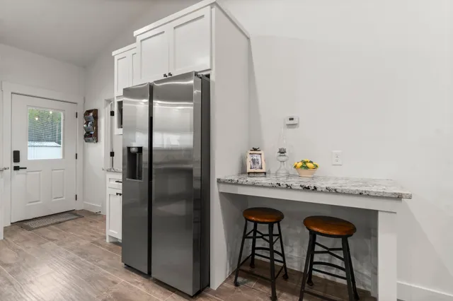 a kitchen with stainless steel appliances granite countertop a refrigerator and a stove top oven