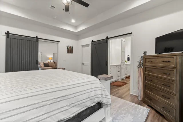 a bedroom with a bed and a flat tv screen on dresser