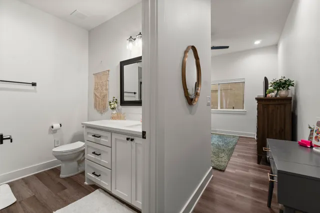 a spacious bathroom with a toilet a sink and mirror