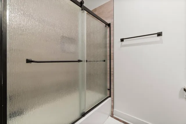 a bathroom with a glass shower door