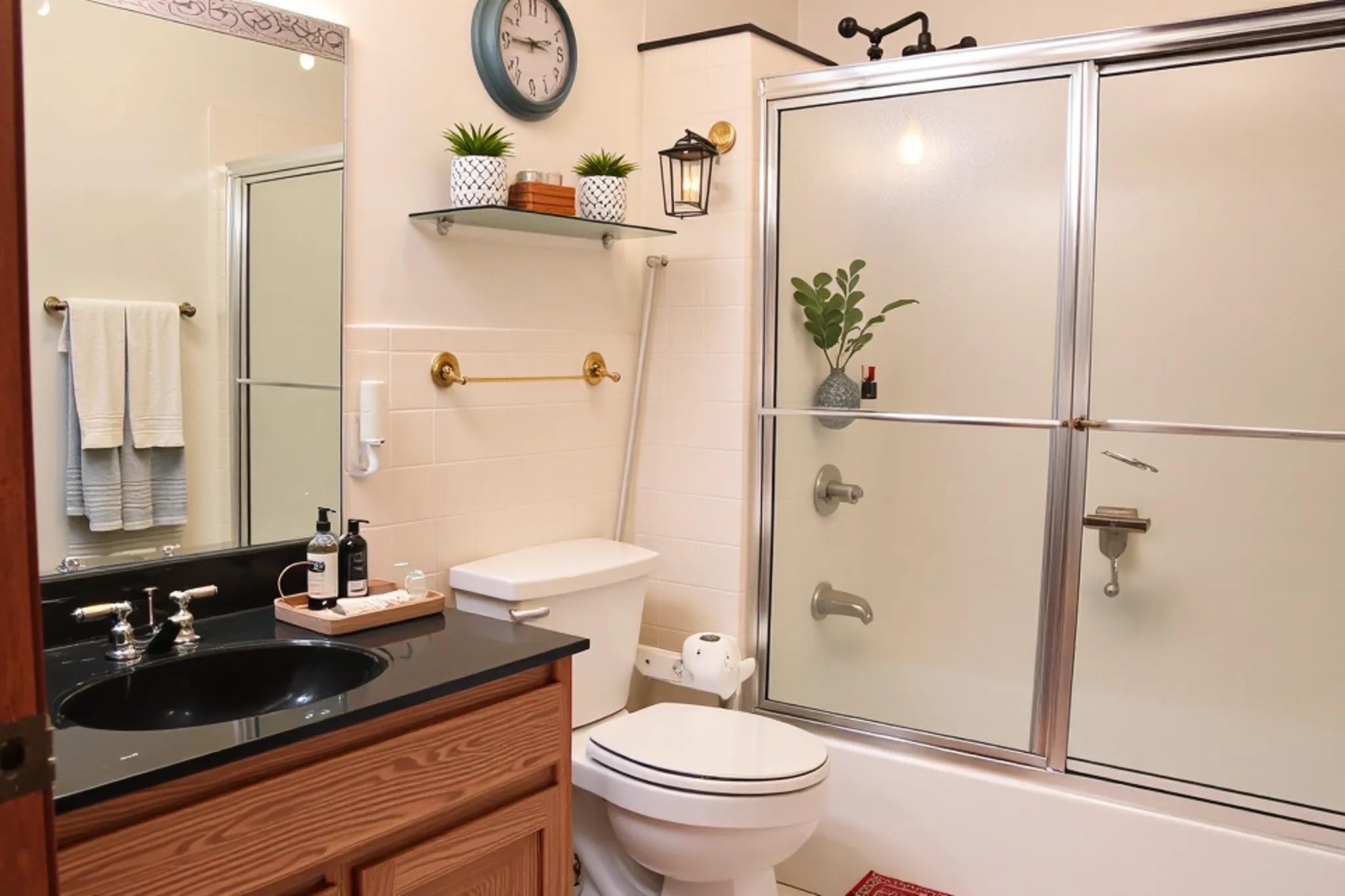 937 Kelleys Chapel Road Burlison, TN 38015 - Photo 19 of 40 Bathroom featuring a wood-finish vanity with a black countertop and integrated sink, a large mirror, a shower-tub combination with sliding doors, and white tile walls