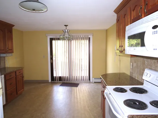 a view of a livingroom with wooden floor and a fireplace