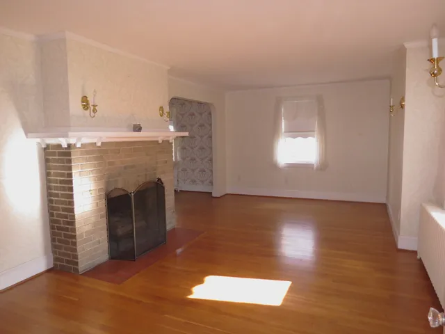 a view of a livingroom with wooden floor and a chandelier