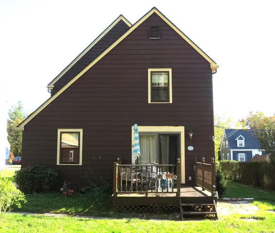 a wooden bench sitting in front of a house