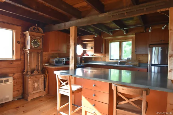 a view of an empty room with wooden floor and windows