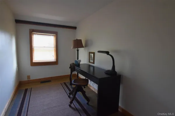 a spacious bedroom with a bed and a dresser next to a window
