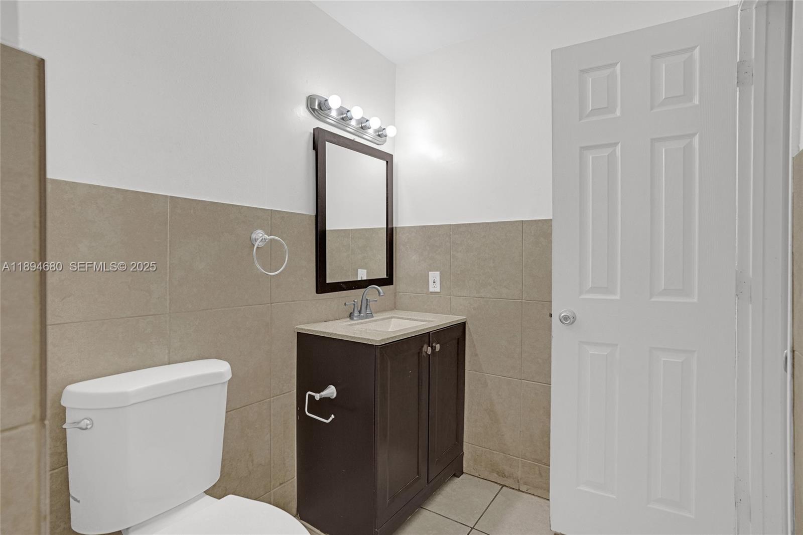 3876 Northwest 207 St Road Miami Gardens, FL 33055 - Photo 20 of 37 a bathroom with a toilet a sink and mirror