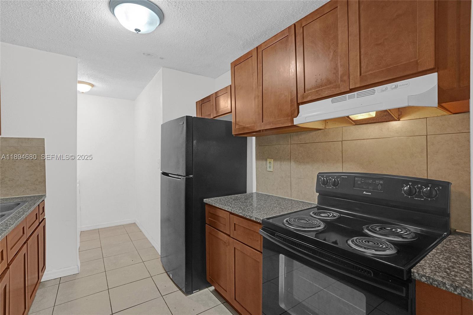 3876 Northwest 207 St Road Miami Gardens, FL 33055 - Photo 4 of 37 a kitchen with a stove and a refrigerator