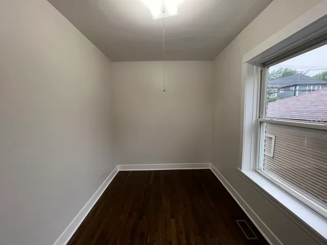 a view of a hallway with wooden floor and a window