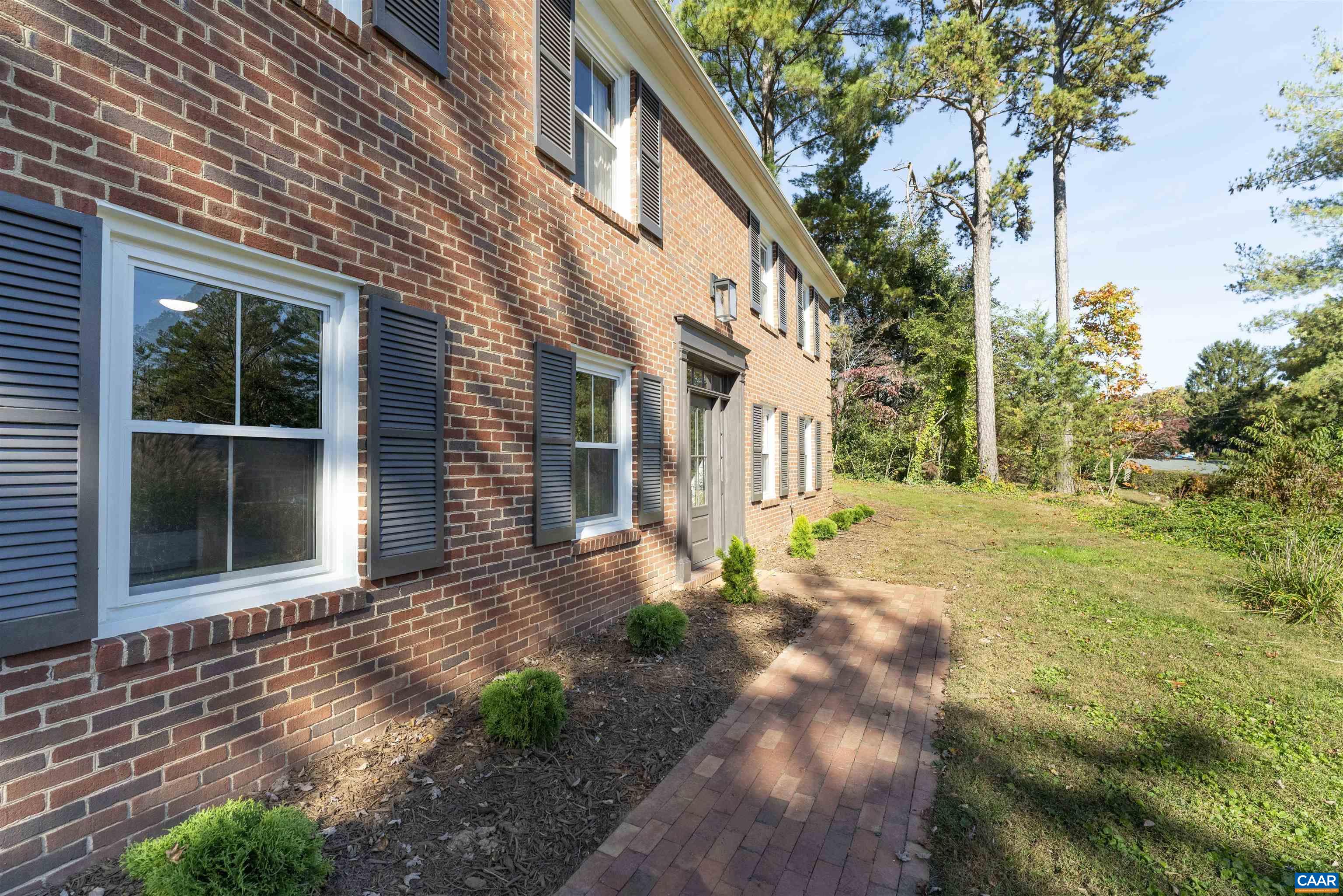 205 Chaucer Road Charlottesville, VA 22901 - Photo 42 of 43 a view of a white house with a large windows and flower plants
